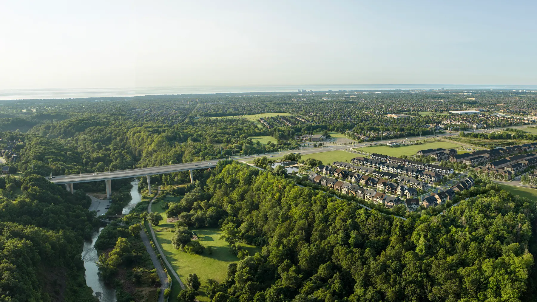 Artist's concept: aerial view of the Five Oaks community beside the wooded creek valley